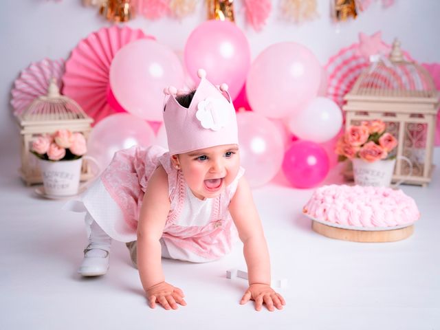 niña con corona de cumpleaños. de fondo globos, flores y un pastel