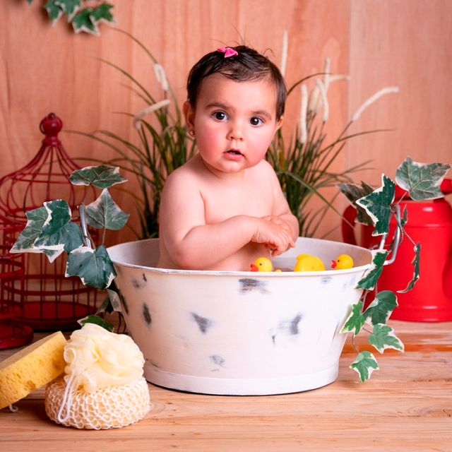 bebe bañándose en un barreño con patitos de goma