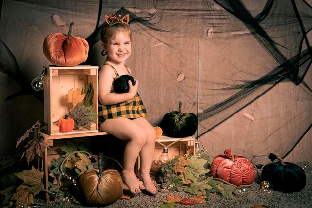 niña con vestido a cuadros posando con decoración de halloween